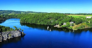 A river with a rocky shoreline and a small settlement with houses and boats.