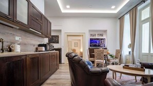 A modern kitchen with dark wooden cabinets, a built-in oven, and a coffee machine. - The Royal Hlavna - Balcony Apartment (Old Town, Košice)