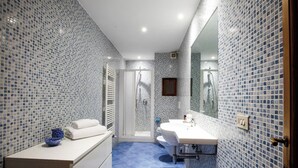 Ein Badezimmer mit Dusche, Waschbecken und Spiegel.