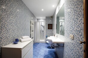 A bathroom with a shower, a sink, and a mirror. - Elegant 2BR Apartment (Firenze)