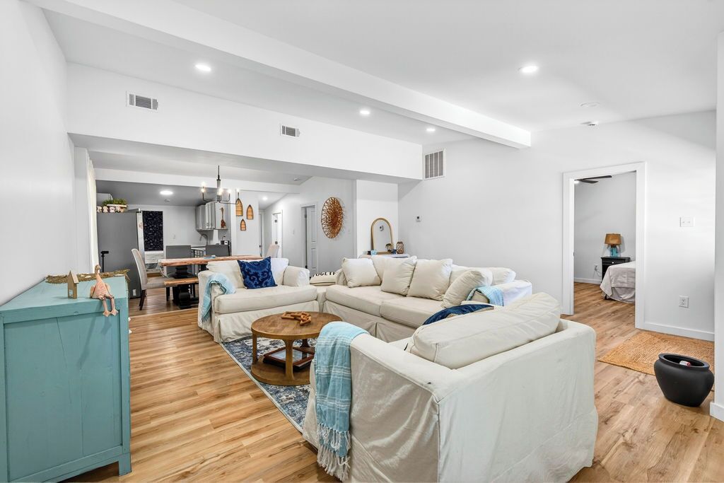 A spacious living area with a sofa set, a coffee table, and a teal cabinet.