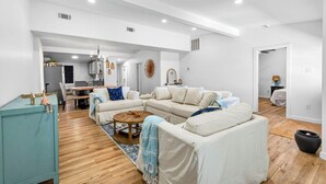 Un salón amplio con un conjunto de sofás, una mesita de centro y un mueble azul verdoso.