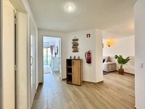 A hallway with a wooden cabinet, a fire extinguisher, and a wall with motivational signs. - Vilamoura Central Beach 1 by Homing (Loulé)
