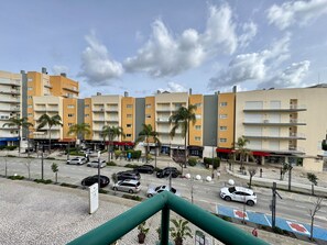 A multi-story hotel with balconies, a parking lot, and a street with cars. - Vilamoura Central Beach 1 by Homing (Loulé)