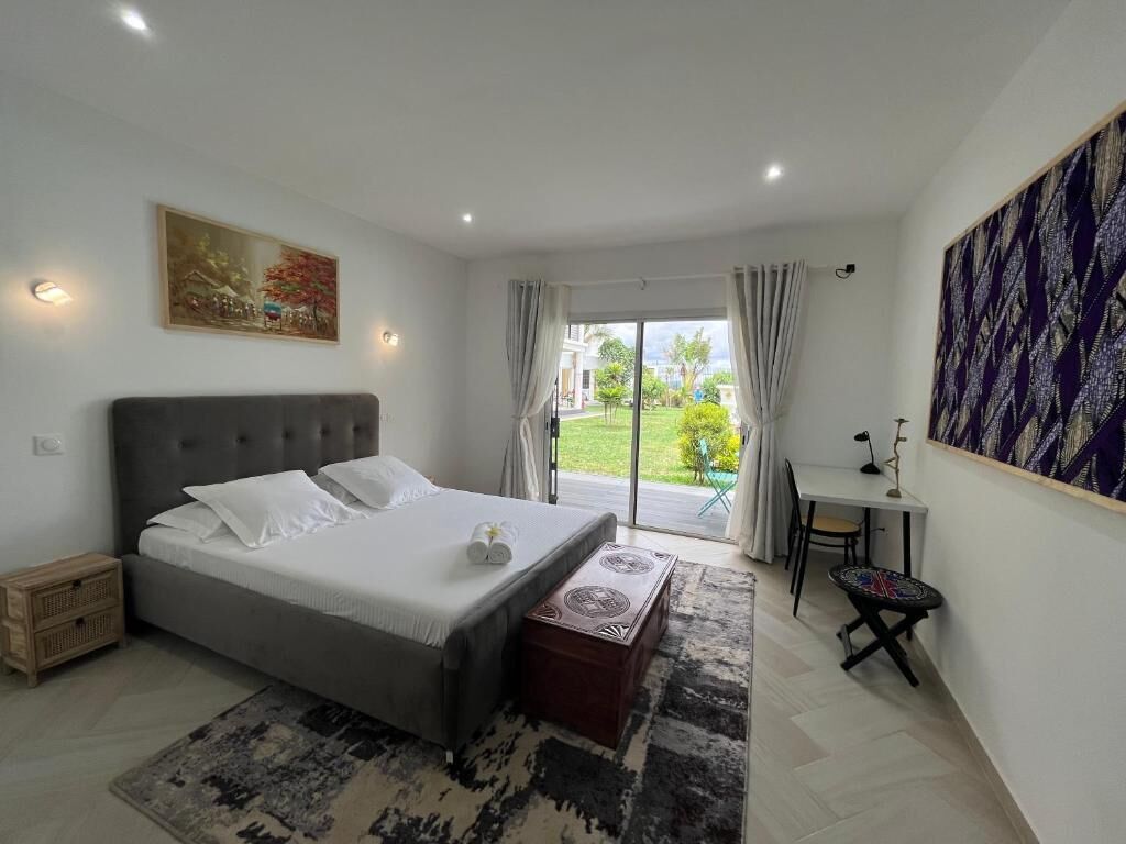 Une chambre à coucher avec un lit, un bureau et une vue sur l’extérieur.