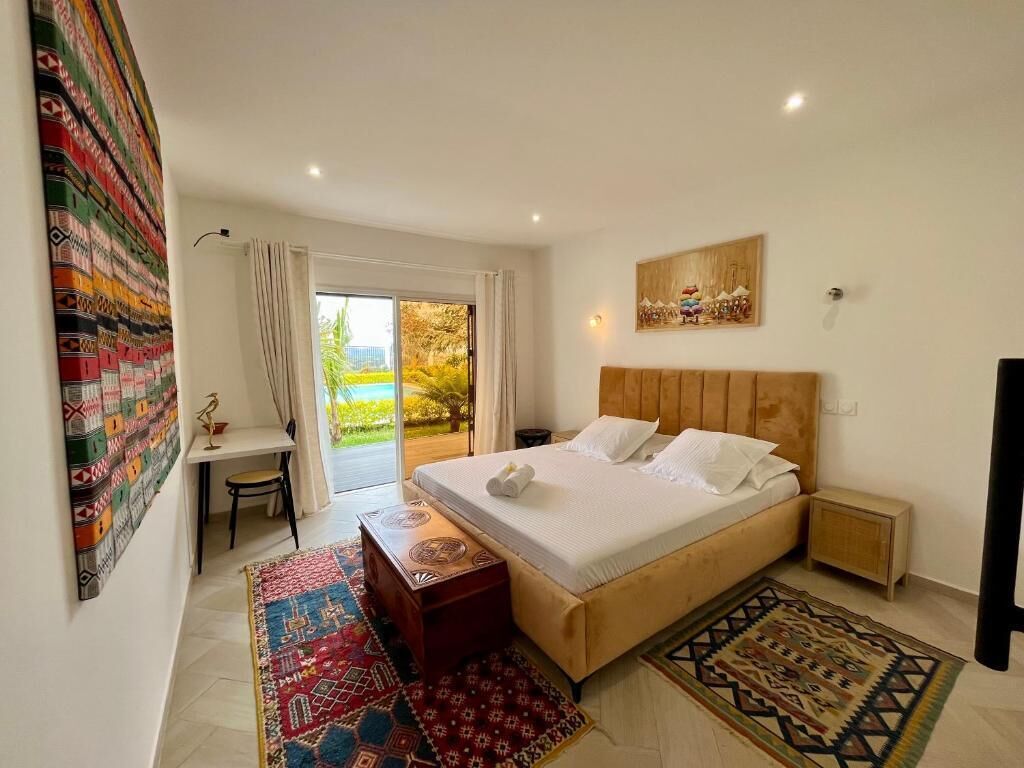 Un dormitorio con cama, escritorio y vistas al exterior.