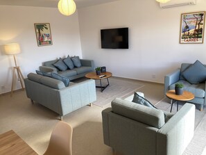 A modern living room with a grey sofa set, a coffee table, a TV, and a lamp. - Villa central Cannes-4BR/3BA/8P-AC-free parking-12’ walk to Palais des Festival (Cannes)