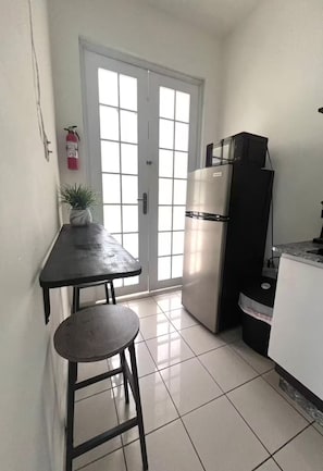Eine Küche mit Kühlschrank, Mikrowelle, Spüle und einem Fenster mit Blick.