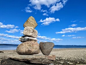 A stack of rocks on a rocky shore with a clear blue sky and calm sea in the background. - Romantic Waterfront Cottage with Private Beach & Fireplace Near Hancock, Maine (Hancock)