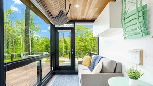 Een modern interieur met een bank, een tafeltje en uitzicht op de omgeving.