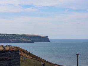 Eine Küstenlandschaft mit einer Wiese und einer Klippe mit Blick aufs Meer.