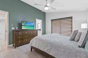 A bedroom with a bed, dresser, television, and a ceiling fan. - Luxury Home/Heated Pool/TPA Airport/Disney (Tampa)