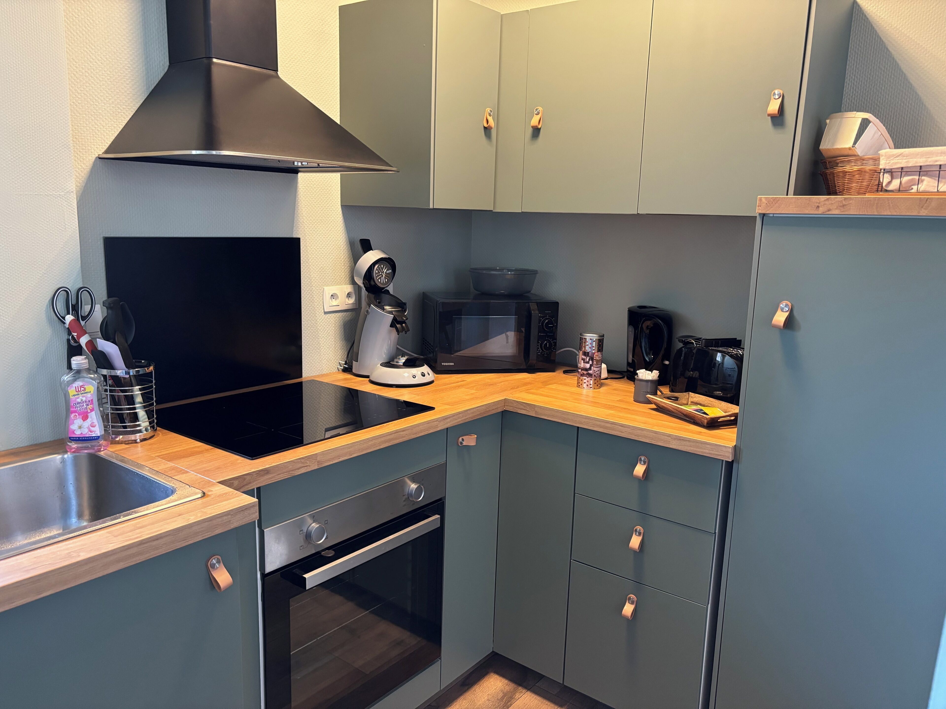 Cocina compacta equipada con microondas, tostadora y cafetera.