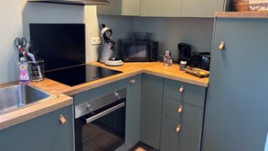 Ett kompakt kök med mikrovågsugn, brödrost och kaffebryggare.