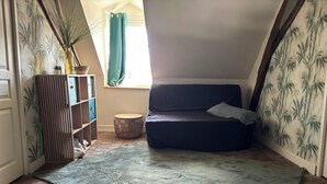 Ett mysigt rum med en mörk soffa, ett litet runt bord och en grön matta.