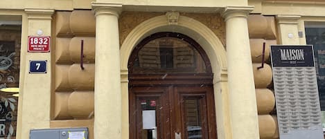 A historic building with a large wooden double door, ornate architectural details, and a plaque indicating the year 1832.