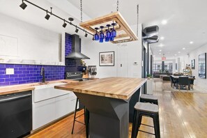A modern kitchen with a wooden island, blue backsplash, and pendant lighting. - Spacious 2-bdrm apartment in vibrant NY's East Village Available Aug 12- Sept 30 (New York)