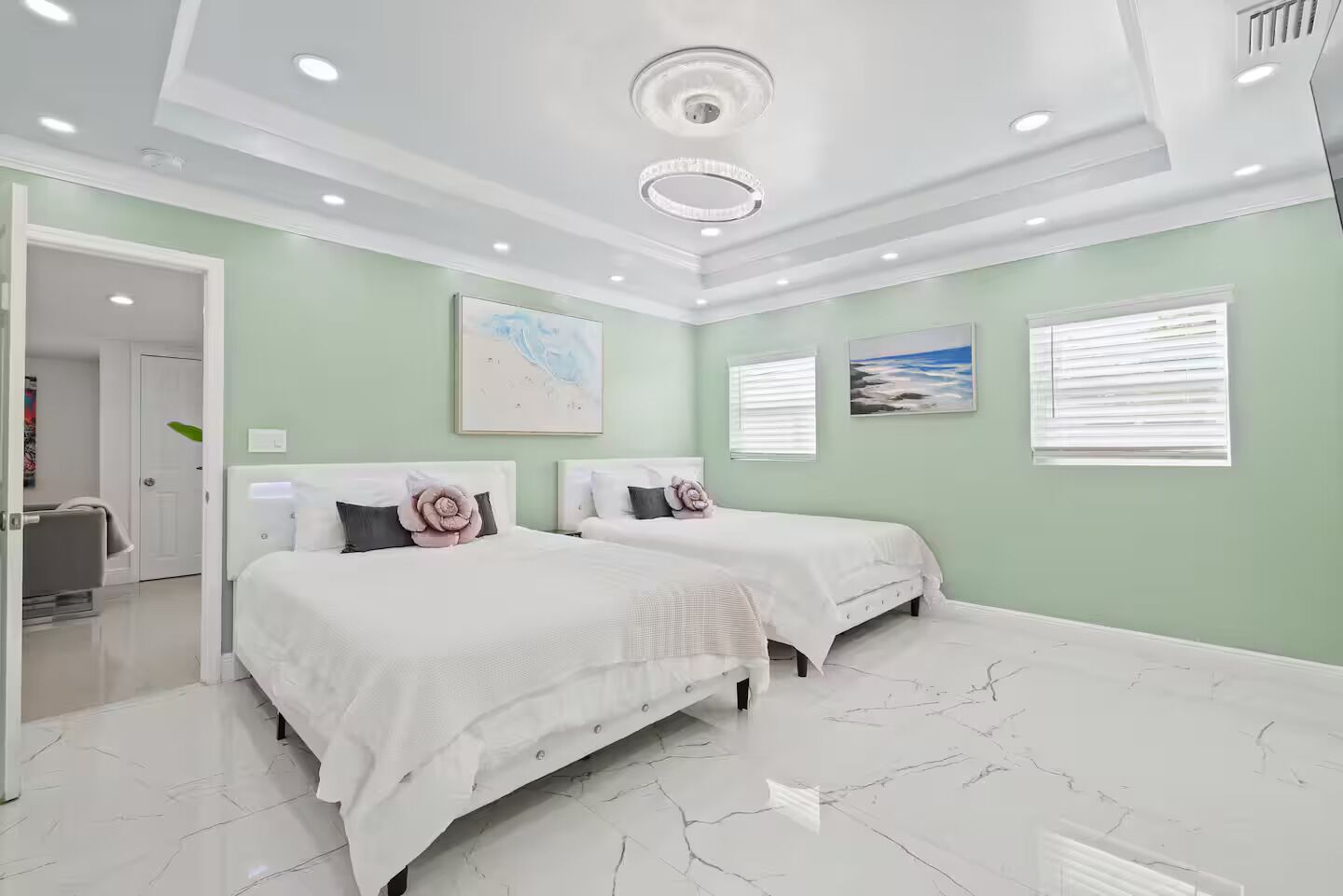 Habitación de hotel con dos camas, un baño y vista al océano.