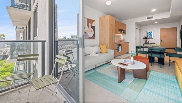 Ein modernes Apartment mit Balkon, Essbereich und Wohnzimmer.