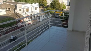 A balcony with a metal railing overlooking a street with vehicles and buildings. - Enjoyable 2-bedroom apartment with AC in Cartagena de Indias (Cartagena de Indias)