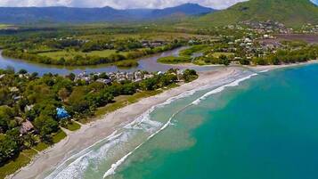 A coastal landscape with a river, beach, and residential area.