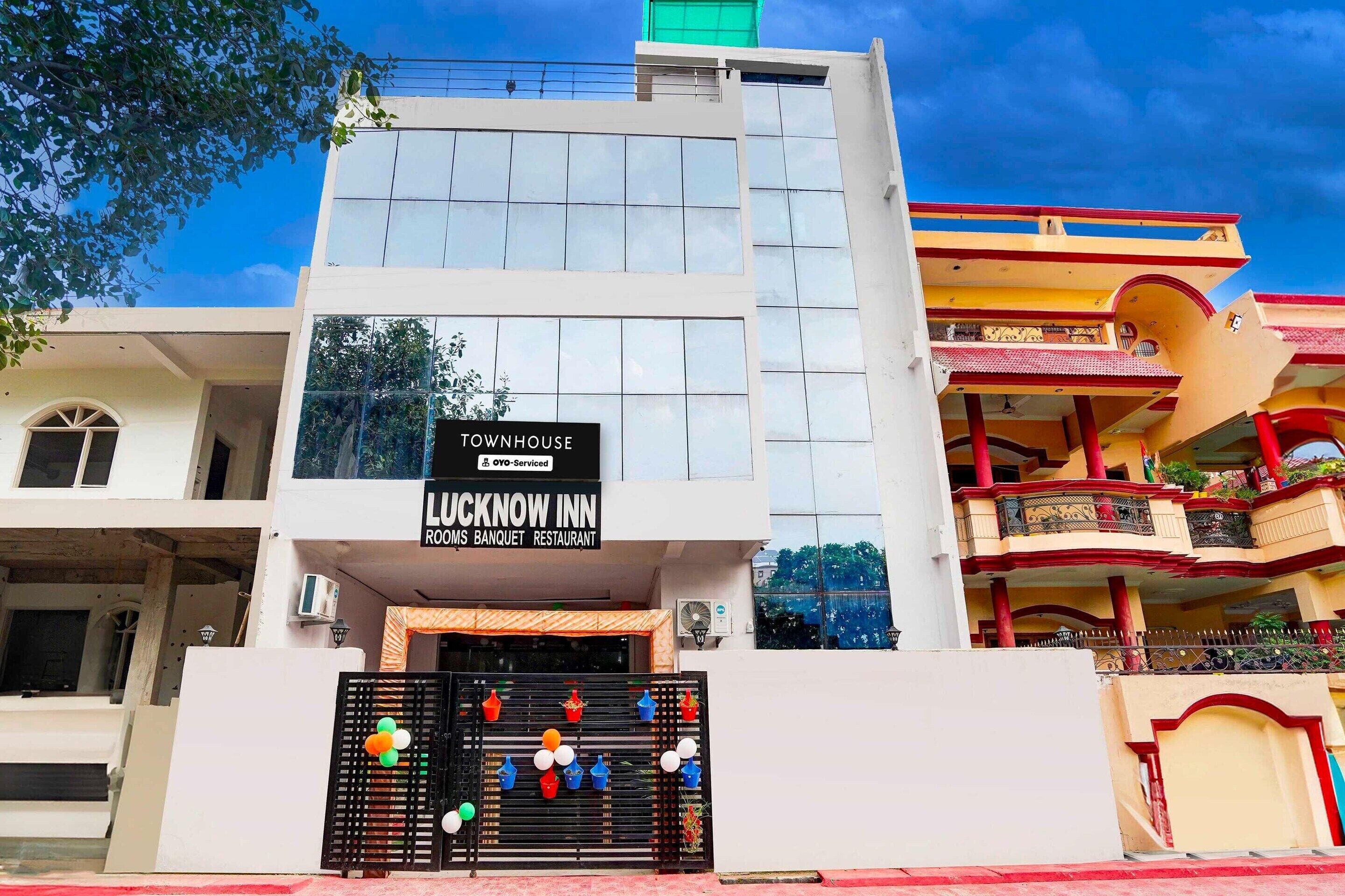 A building with a sign for 'Lucknow Inn' indicating it is a rooms, banquet, and restaurant.