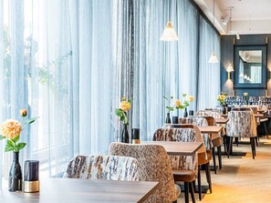 A restaurant with long tables, chairs, and hanging pendant lights. - Ride, Unwind & Explore The Hague | Suite Stay | Museum Beelden aan Zee - 0.2 mi (Den Haag)