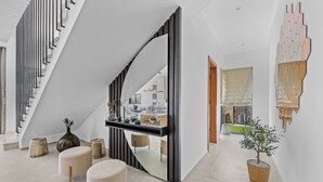 Ein modernes Interieur mit Treppe, einer Konsolentisch und einem Topfpflanzen.