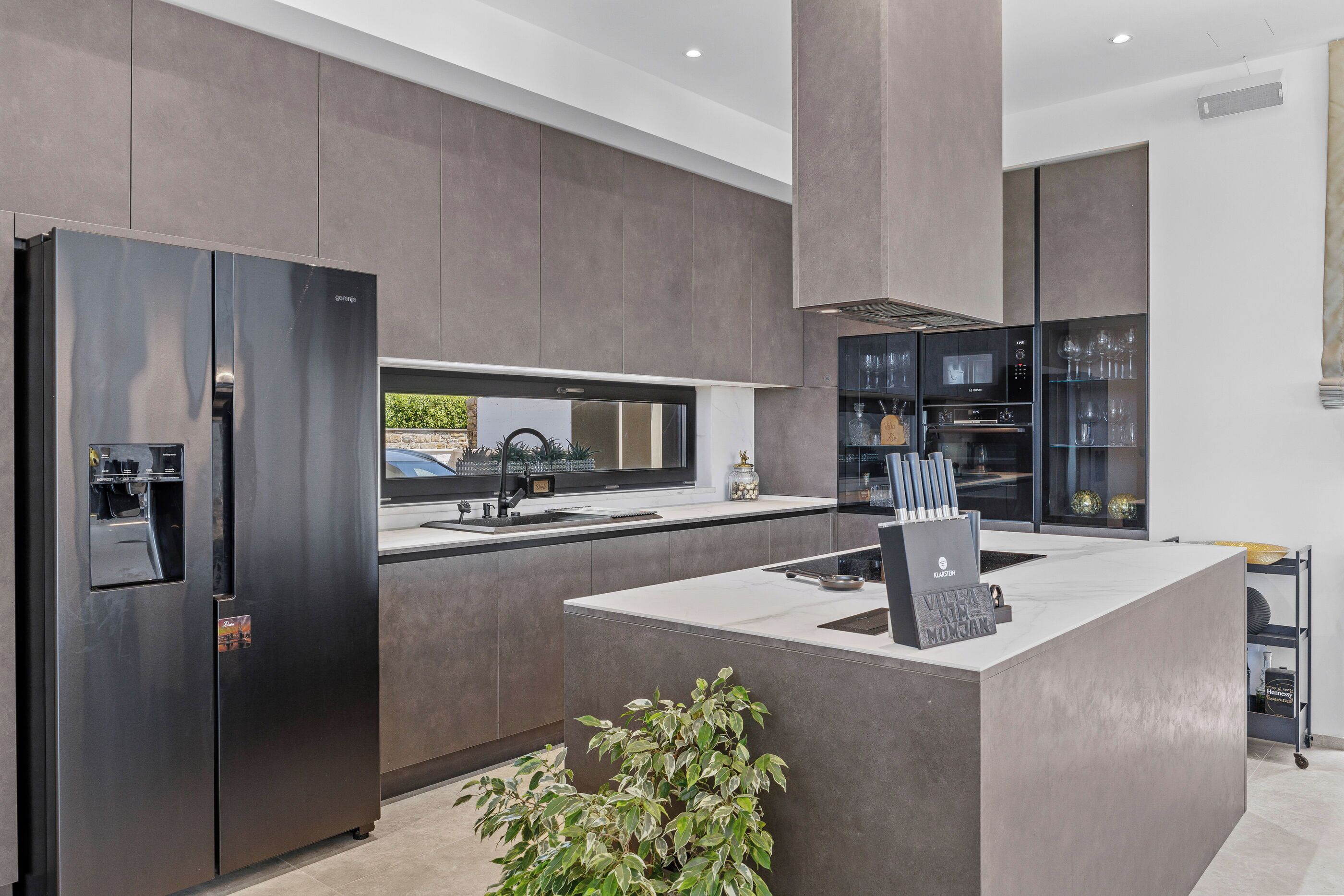 A modern kitchen with a built-in refrigerator, a central island, and a microwave.