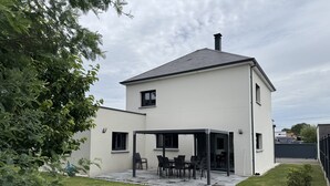 A two-story house with a covered patio area. - Vacation home 3 min from Le Mans 24H circuit with terrace, private garden, and Wi-Fi (Changé)