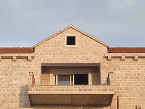 Un bâtiment en pierre doté d’un petit balcon et d’une fenêtre.