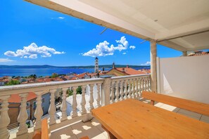 A balcony with a view of the sea and a tower. - Apartments Andrijanic (Crikvenica)