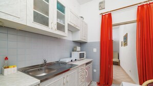 Eine kleine Küche mit Spüle, Mikrowelle und Schränken.