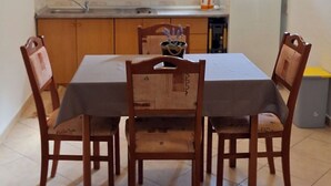 Une petite cuisine avec des meubles en bois, un four à micro-ondes, un évier et un réfrigérateur.