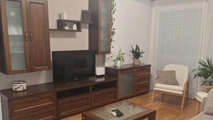 A living room with a sofa, coffee table, TV stand, and cabinets. - Apartment Goran (Makarska)