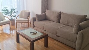 A living room with a sofa, armchair, and coffee table. - Apartment Goran (Makarska)