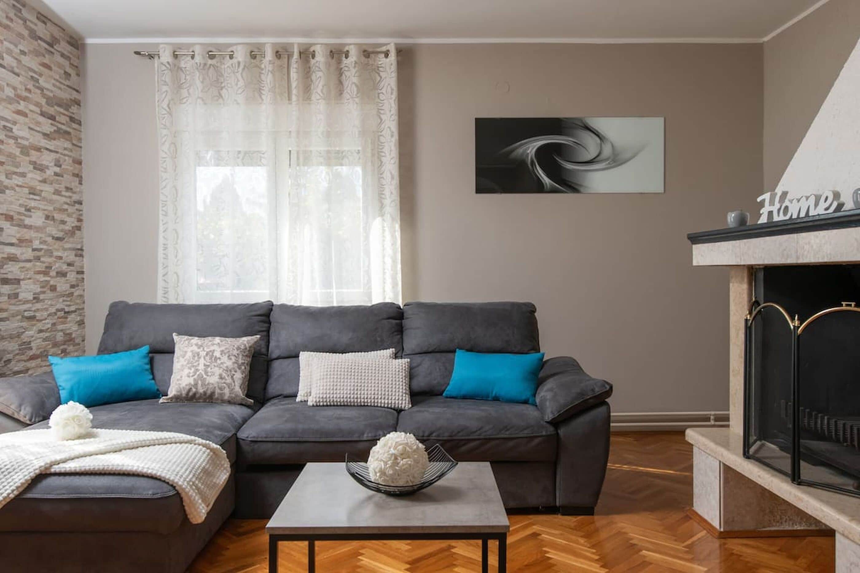 A living room with a grey sofa, a white coffee table, and a fireplace.