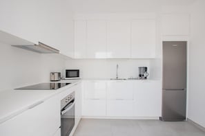 A modern kitchen with white cabinetry, a stainless steel refrigerator, a microwave, a toaster, and a coffee maker. - Villa Montane 10 - Three Bedroom Villa, Sleeps 6 (Playa Blanca)