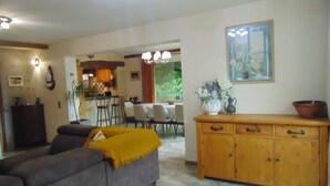 A living room with a sofa, a wooden cabinet, and a dining area with chairs and a table. - "A Provençal Getaway for Two in Haute-Provence" (Revest-Saint-Martin)