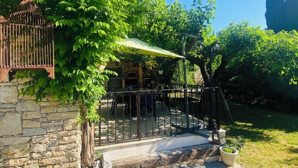 A courtyard with a stone wall, a pergola, and a seating area. - "A Provençal Getaway for Two in Haute-Provence" (Revest-Saint-Martin)