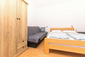 A bedroom with a wooden wardrobe, a sofa, and a bed. - Apartments Sweet Pasman (Pasman)