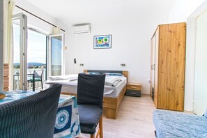 Ein Schlafzimmer mit Bett, Stuhl, Tisch und einem Holzschrank.