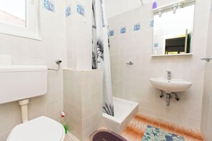 Ein Badezimmer mit Toilette, Dusche und Waschbecken.