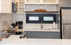 Una cocina moderna con un refrigerador de acero inoxidable, un lavamanos doble y una cafetera.