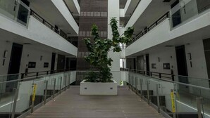 A multi-level atrium with a central staircase, glass railings, and a potted plant. - VIA Braemar Suites - with roof-top pool (Kingston)