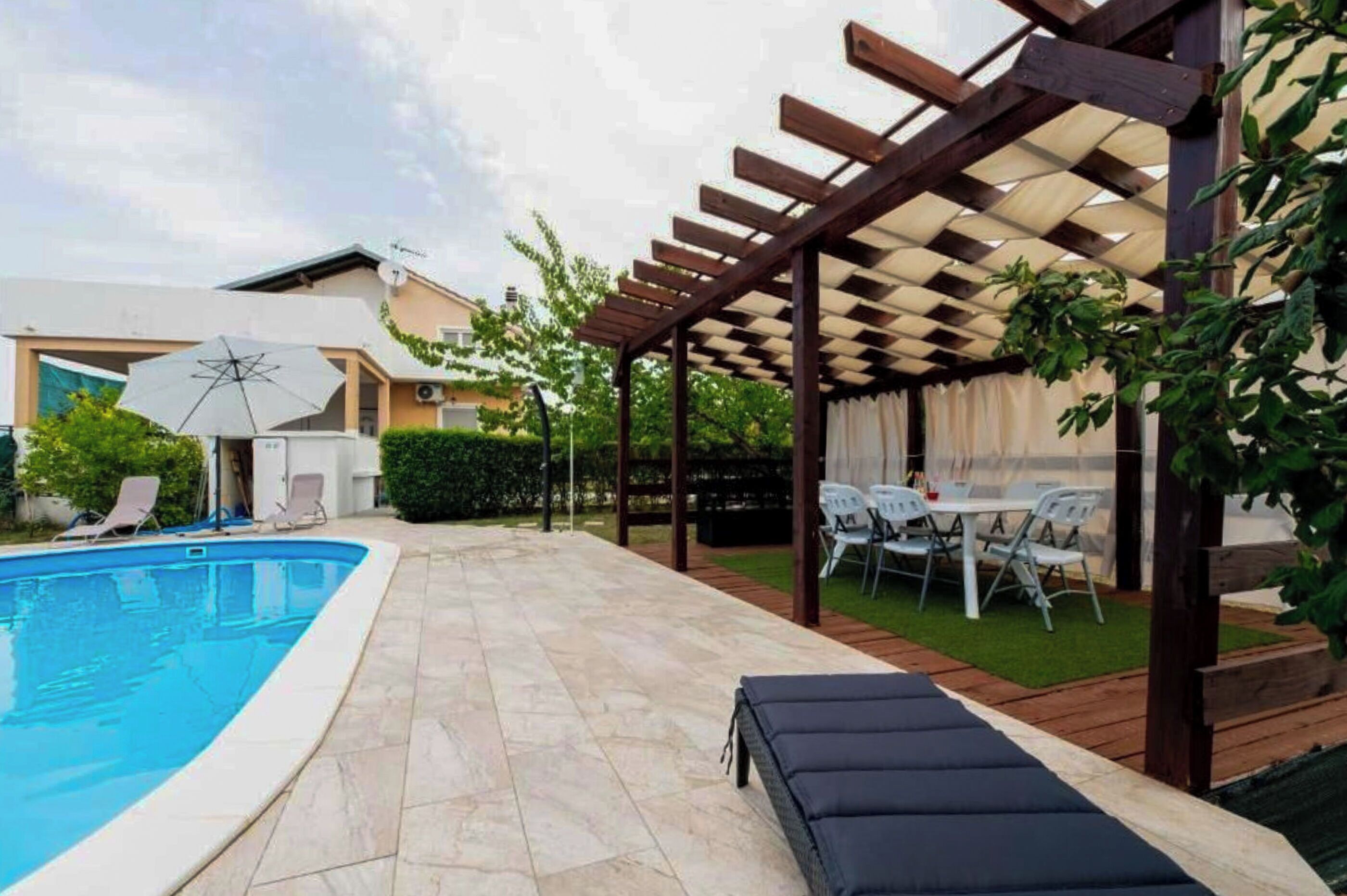 Una piscina al aire libre, sombrillas, tumbonas
