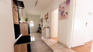 A hallway with a wooden cabinet, a rug, and a door with a cross. - House Bistre With Private Pool (Razanac)
