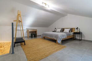 Une chambre avec un lit de style industriel, un bureau, une échelle et une table de chevet.