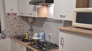 A kitchen with a stove, oven, microwave, and cabinets. - House House Marijan (Karlobag)