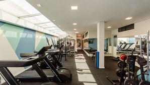 Een sportschool met loopbanden, krachtapparaten en losse gewichten.